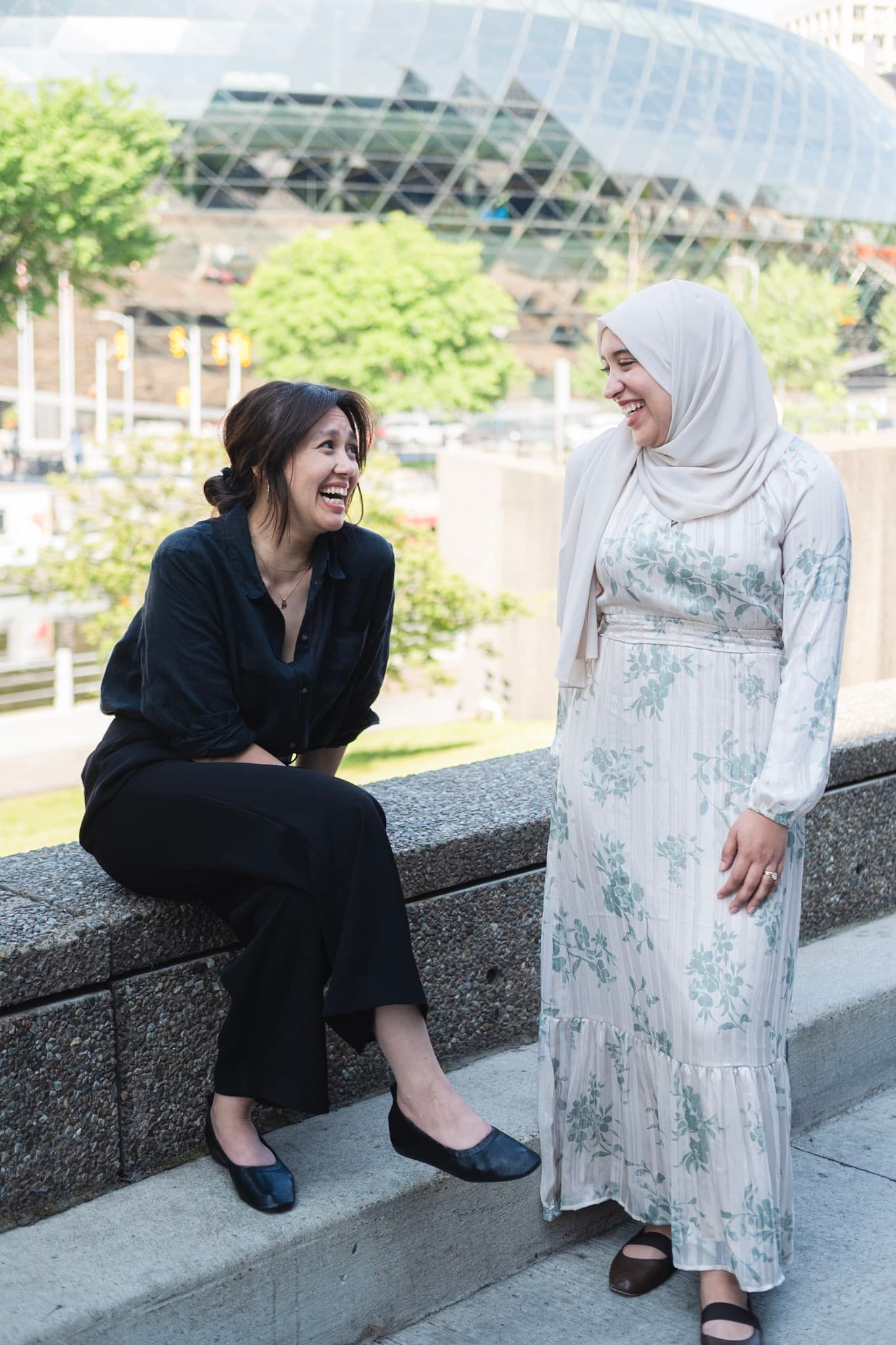 Wala'a Farahat and Samiyah Zawawi sitting together outdoors