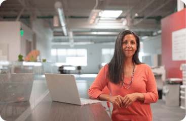 Courses & Workshops — instructor standing with laptop in workshop