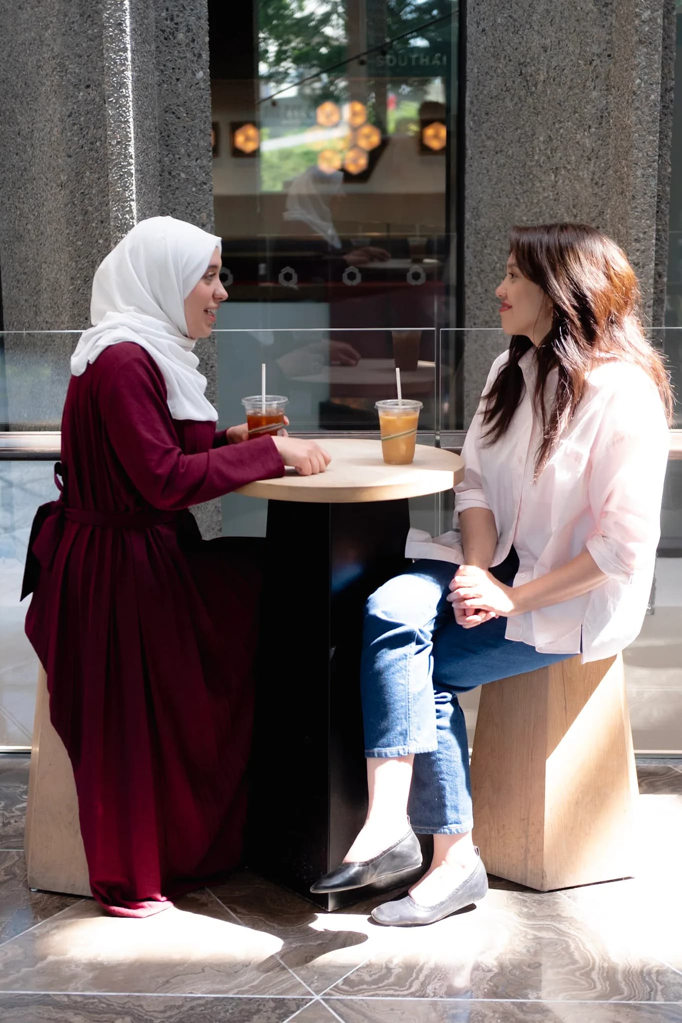 Wala'a Farahat and Samiyah Zawawi sitting together outdoors